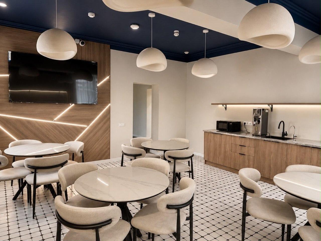 Общая зона с телевизором и кухонным уголком: микроволновка, диспенсер для воды и мойка